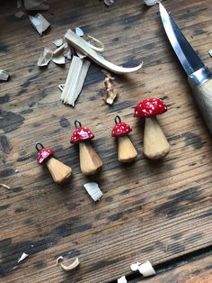 small wooden mushrooms sitting on top of a table next to a pair of scissors