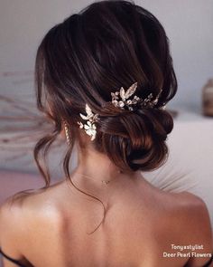 a woman wearing a wedding hair comb with leaves on it's back and side