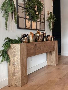 a wooden table topped with potted plants next to a mirror