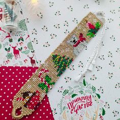 a cross stitch christmas bracelet on top of a table