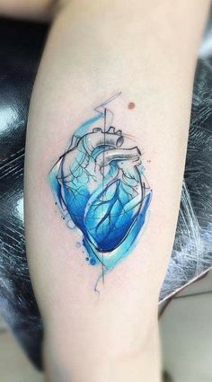 a woman's leg with a blue heart tattoo on her left arm and an arrow in the middle