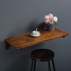 a wooden table with two stools next to it and a cup on the top