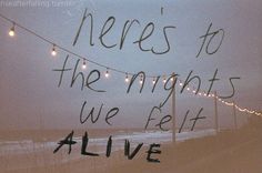 there's to the nights we eat alive written on a window with string lights