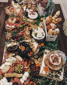 a table filled with lots of food on top of a wooden floor