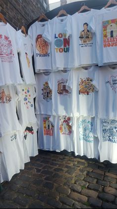 many t - shirts are hanging up on the wall