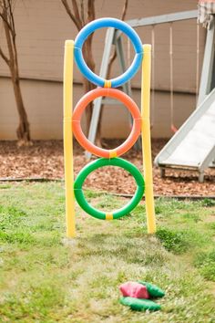 an inflatable ring is on the grass next to a playground slide and toys