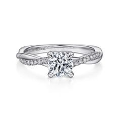 a white gold engagement ring with a twisted band and a round brilliant diamond center stone