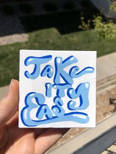 someone holding up a sticker that says take it easy