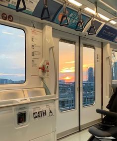 an empty train car with the sun setting in the back ground and windows on both sides