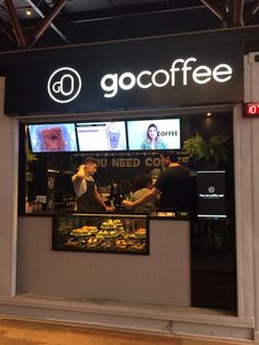 the front window of a coffee shop with people sitting at their desks and talking to each other