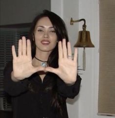 a woman is holding her hands up in the air with one hand and two fingers out