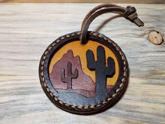 a leather ornament with cactus and mountains on it