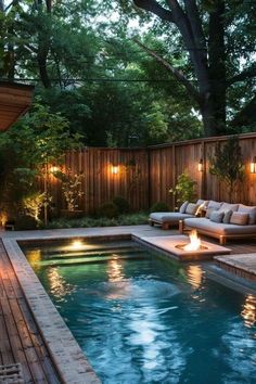 a pool with lights around it next to a wooden deck