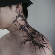 a man with a black hat on his head has a thorn tattoo on his neck