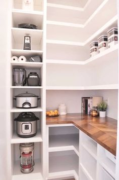 an organized pantry with white shelves and wooden counter tops