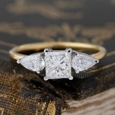 three stone diamond ring on top of an old book