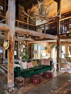 a living room filled with furniture and lots of wooden beams on the ceiling, along with deer antlers hanging from the walls