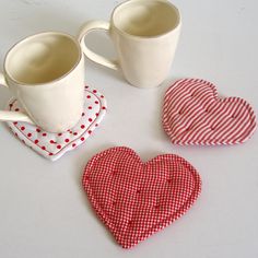 three heart shaped coasters sitting next to each other on top of a white table