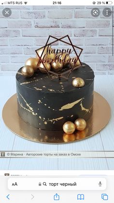 a black and gold birthday cake sitting on top of a table