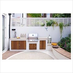 an outdoor kitchen with grill and seating area