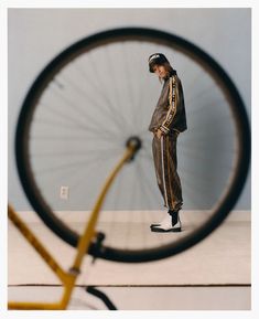 a man standing in front of a bicycle wheel