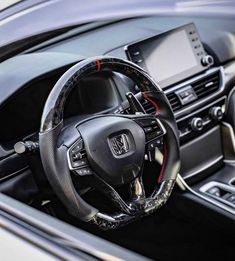 the interior of a car with steering wheel and dashboard