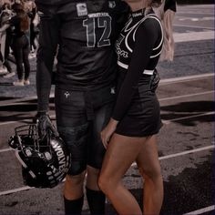 a man and woman in football uniforms standing next to each other