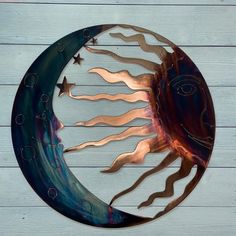 a metal sun and moon decoration on a wooden wall with white boards in the background