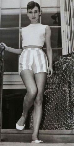 an old black and white photo of a woman in shorts