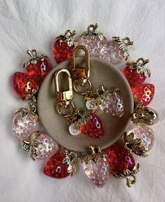 a bunch of charms that are on top of a plate with some red and pink beads