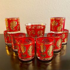 red glass cups with gold designs on them