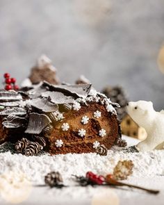 A chocolate yule log covered in icing sugar to resemble snow on a decorated serving tray with a small polar pear figurine looking at it, surrounded by fairy lights Vegan Yule Log, Vegan Sponge Cake, Chocolate Christmas Cake, Dessert For Christmas, Vegan Chocolate Ganache, Christmas Yule Log, Chocolate Log, Chocolate Yule Log, Grape Tree