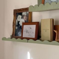 there is a shelf with pictures and books on it