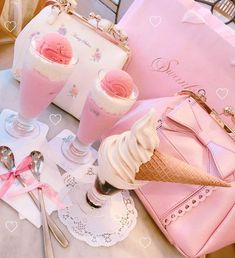 two ice cream sundaes and a pink purse on a table