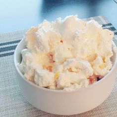 a white bowl filled with whipped cream on top of a table