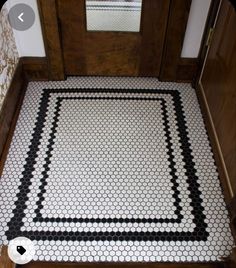 a bathroom floor with black and white hexagonal tiles on the bottom half of it