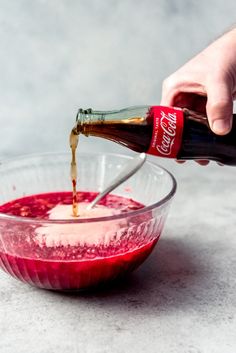 someone pouring sauce into a glass bowl