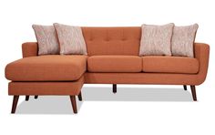 an orange couch with four pillows on it