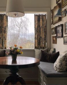 a living room filled with furniture next to a window covered in curtains and drapes