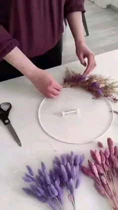 a person is making some flowers out of yarn and scissors on a table with other items