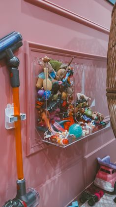 a shelf filled with lots of toys next to a wall mounted hair dryer and blow dryer