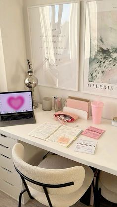 a white desk topped with a laptop computer next to a pink heart shaped object on top of it