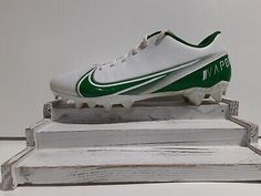 a pair of white and green soccer shoes on top of a wooden platform with the word nike