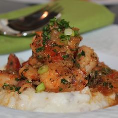 a white plate topped with mashed potatoes and shrimp