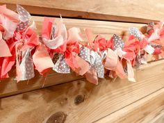 some pink and grey bows are hanging on a wooden wall