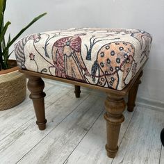 a wooden bench sitting on top of a white floor next to a potted plant