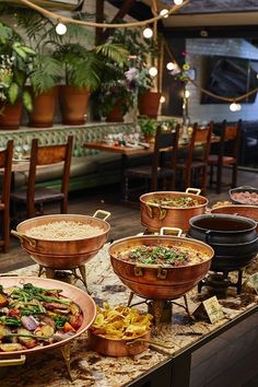 a buffet table filled with lots of different types of food on top of plates and serving utensils