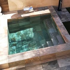 an indoor swimming pool with tiled flooring and walls in the shape of rectangles