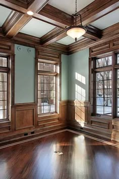 an empty room with wood paneling and windows