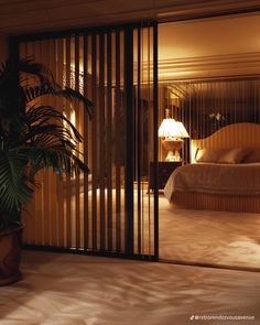 a bedroom with sliding glass doors leading to a large bed in the background and a potted plant next to it